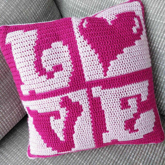 Pink cushion in four segments showing the word LOVE with the O as a heart shape