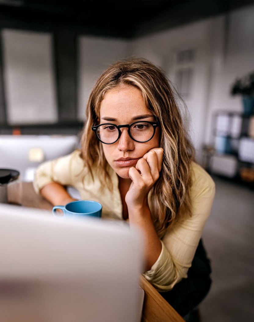 woman looking at laptop stressed out but finally choosing a personal coaching experience with meroyoga