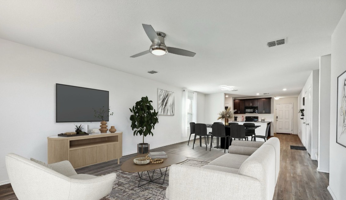 Open-concept living and dining room with modern furnishings, neutral tones, wood-style flooring, and natural light — highlighting a clean and spacious home interior.
