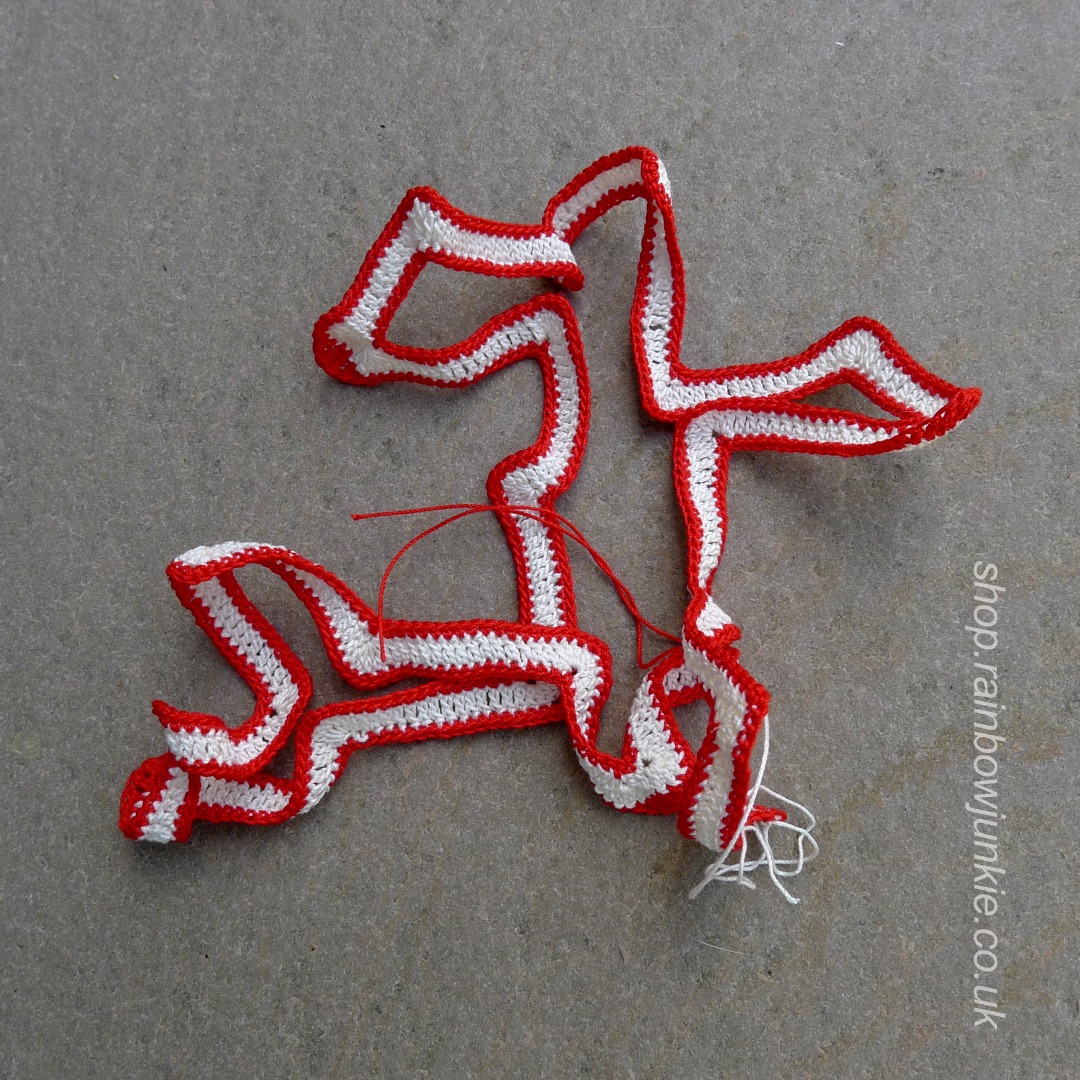 Long crochet ribbon that is folded into a Celtic Bookmark.