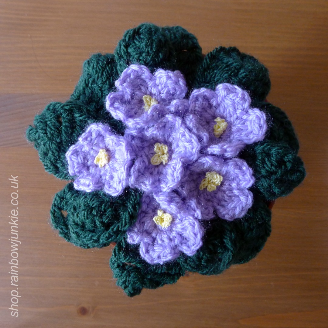 Lavender coloured crochet African Violets seen from above.