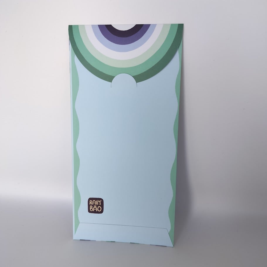 Back of a pastel money envelope with purple, blue, and green rainbow arc pattern on the closing flap.