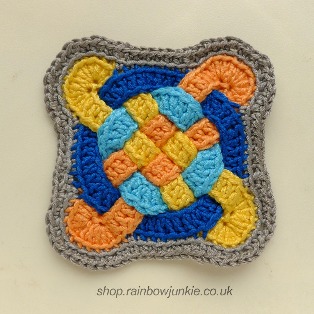 Edged Celtic Coaster in yellow, orange, dark blue and pale blue.