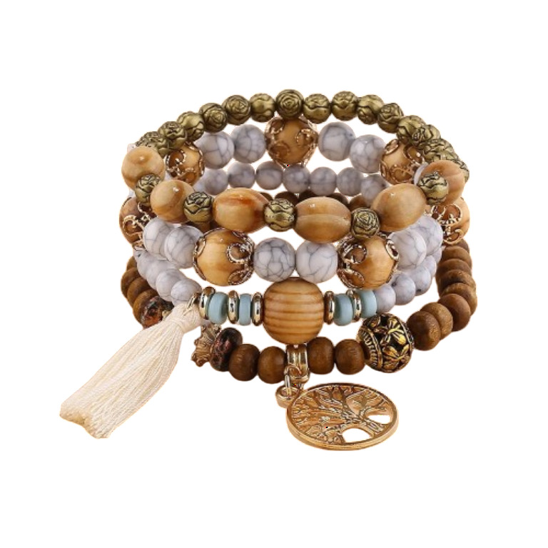Stacked ladies multi-strand beaded bracelet set featuring a prominent gold-tone Tree of Life charm, a cream tassel, and a mix of natural brown wood beads, white howlite-style stone beads, turquoise accents, and antique gold-tone decorative metal beads. B