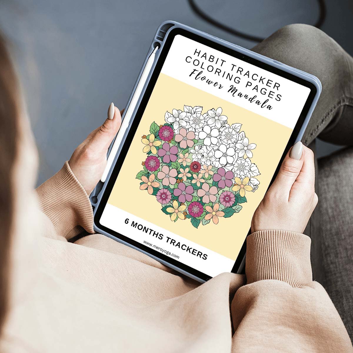 woman holding tablet with cover from habit tracker flower mandala