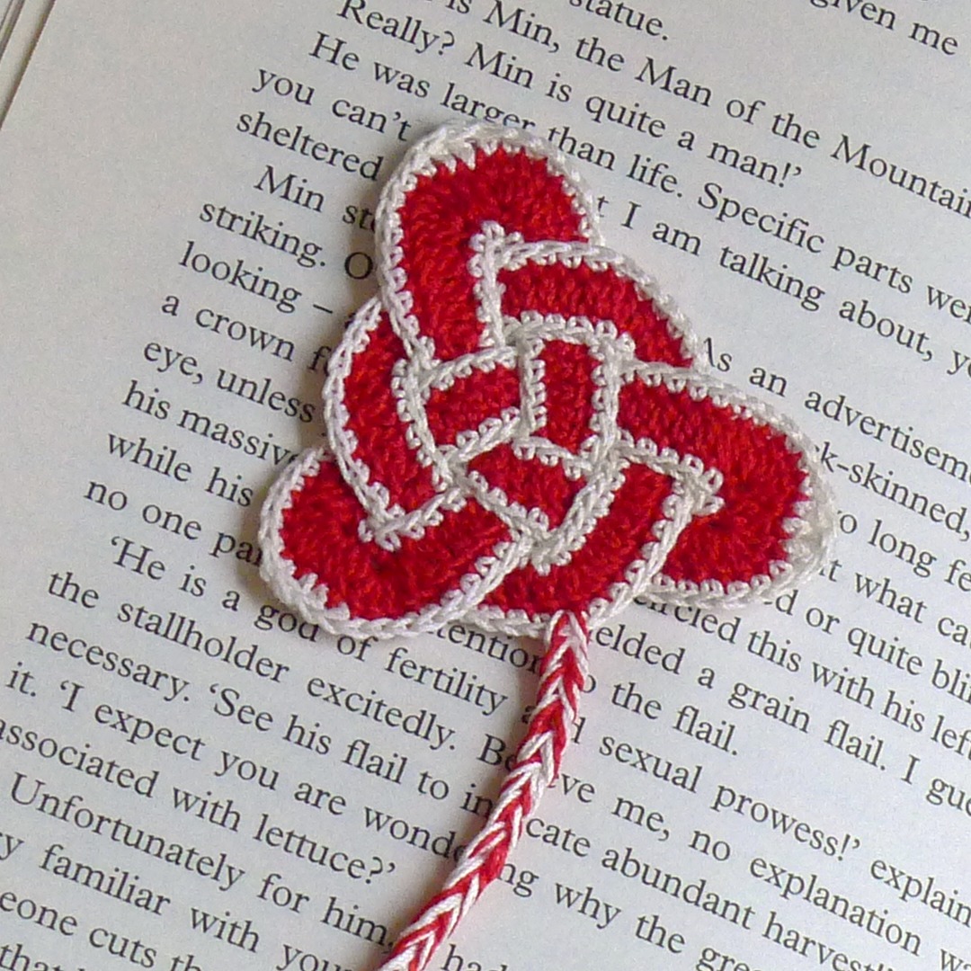 Triquetra pattern used to make a bookmark shown on top of a page from a book.