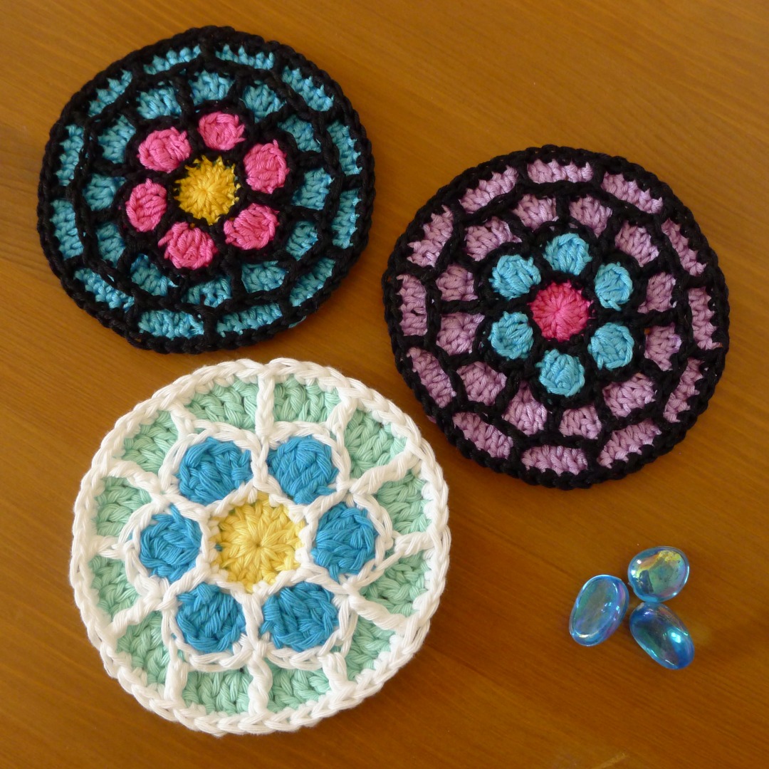 Three Rose Window Coasters, two in DK cotton yarn.  and one in Aran cotton yarn.