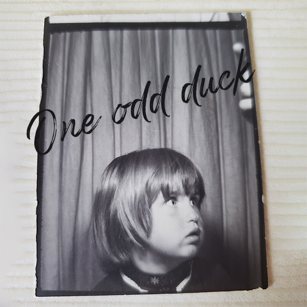 The author as a child in a photo booth with her dad's finger pointing at the camera to get her to look that way.