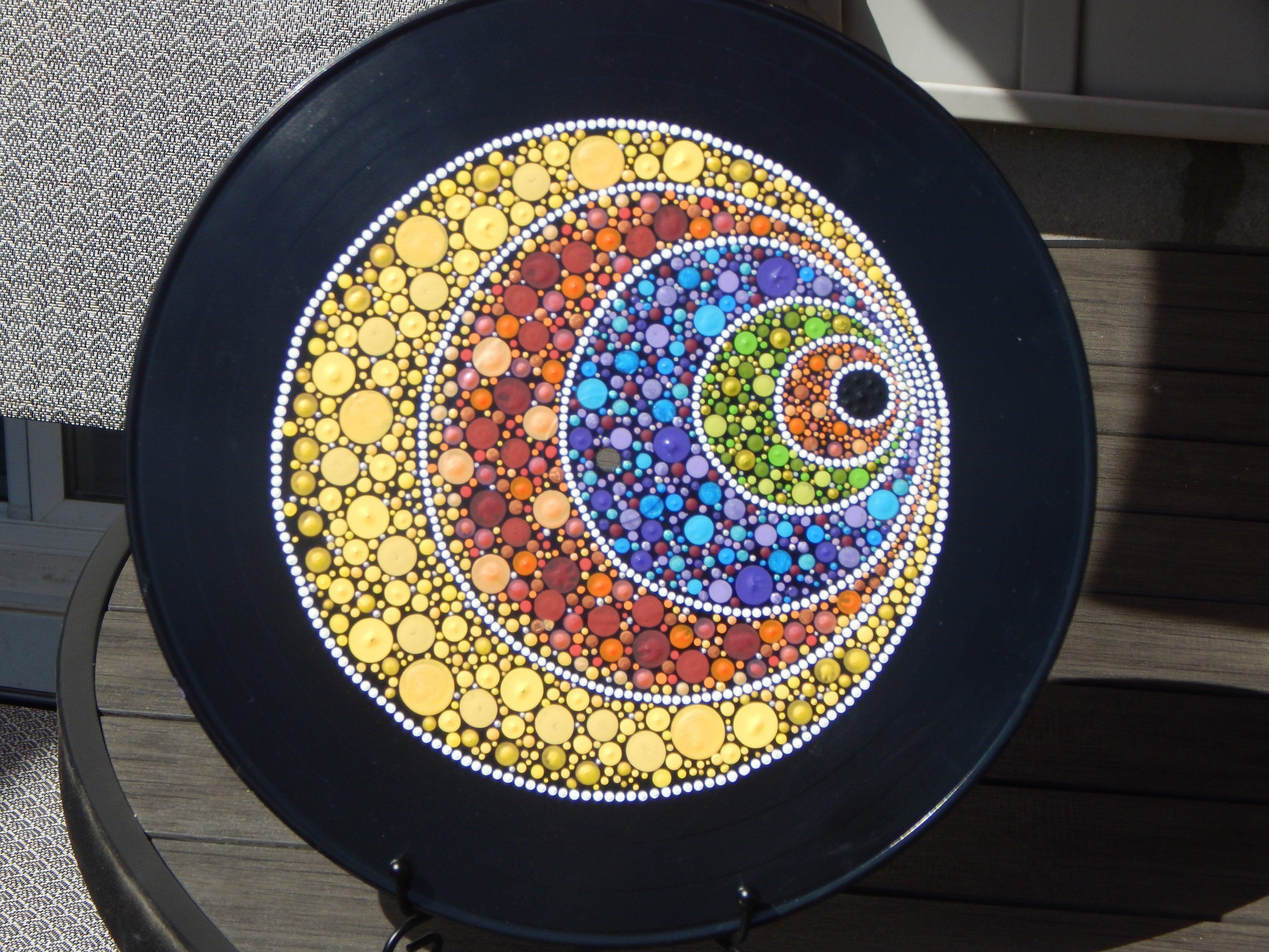 Vibrant dot mandala painted on an upcycled vinyl record, featuring swirling colors and a hypnotic design inspired by moonlight and mystic eye energy. This handmade piece blends sustainable art with mindful creativity — a colorful expression of ADHD-fueled joy from What in Narnation.