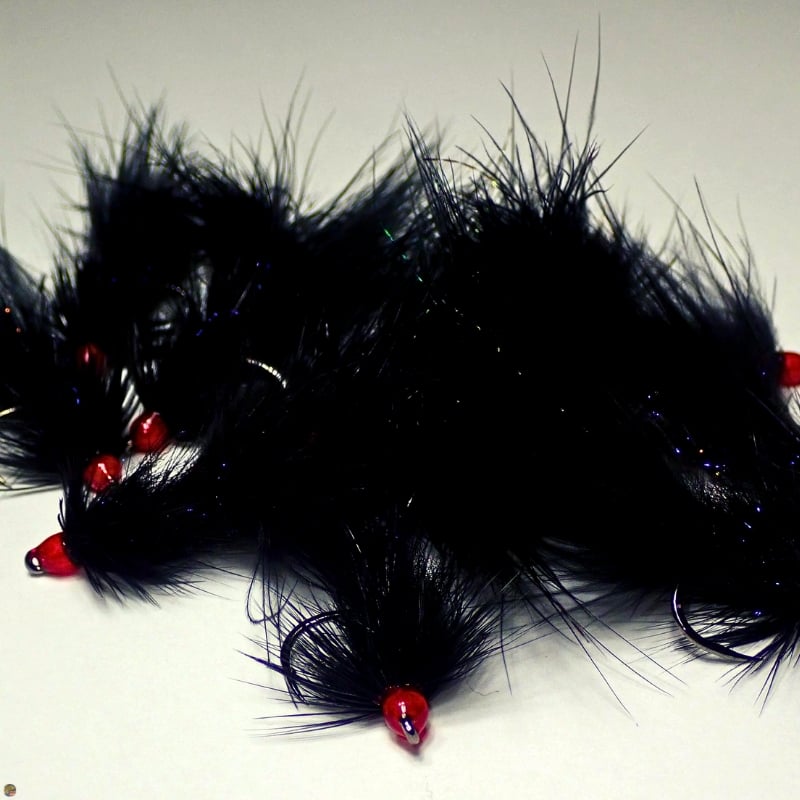 Close-up of a pile of black Egg Sucking Leech flies tied by Matt Campbell, The Fly Guy.