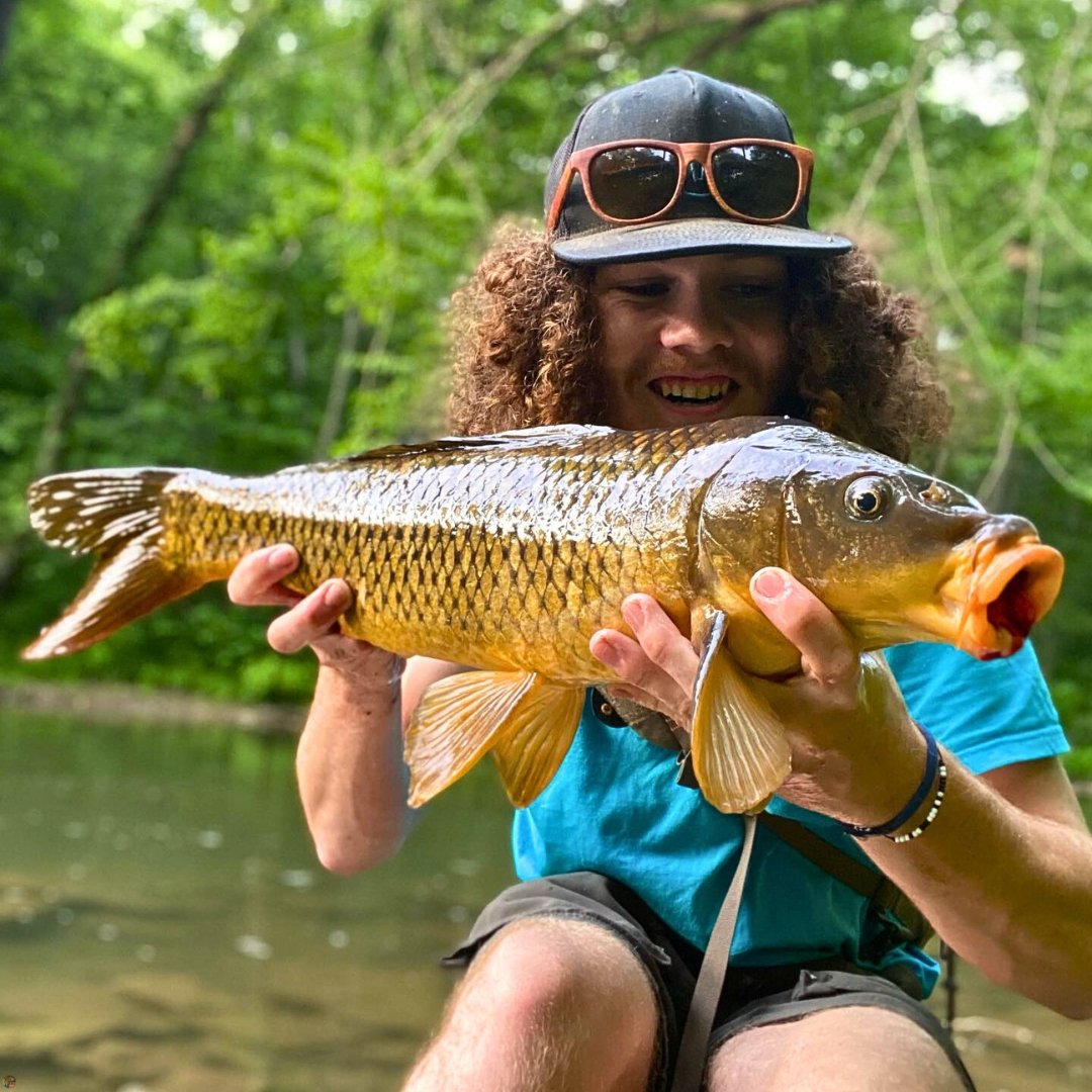 Young fly angler holding a golden carp caught on the Carp Vader Dark Hybrid fly tied by Matt Campbell, The Fly Guy.