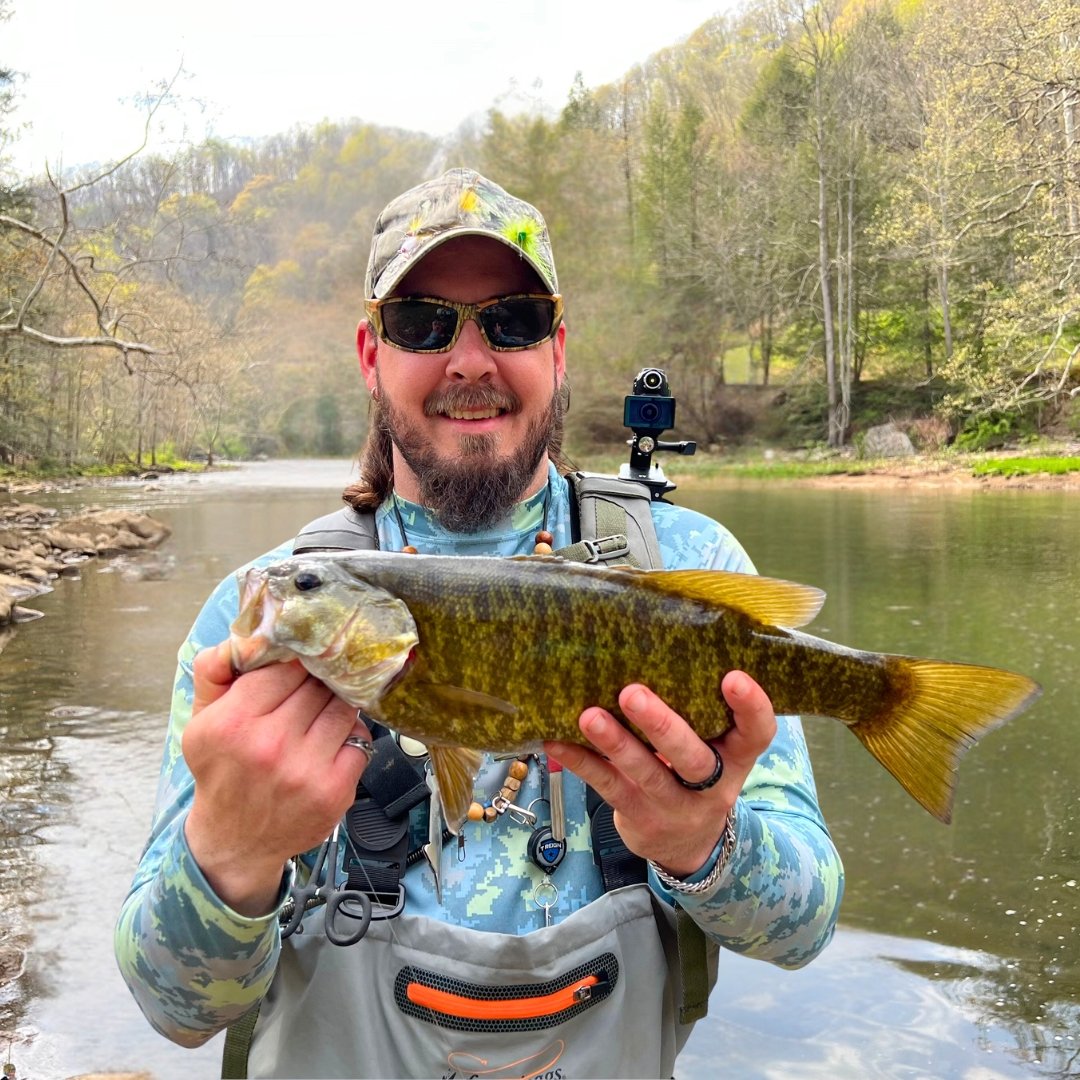 Fly fishing guide Matt Campbell holding a large smallmouth bass caught on the Youghiogheny River in Maryland.