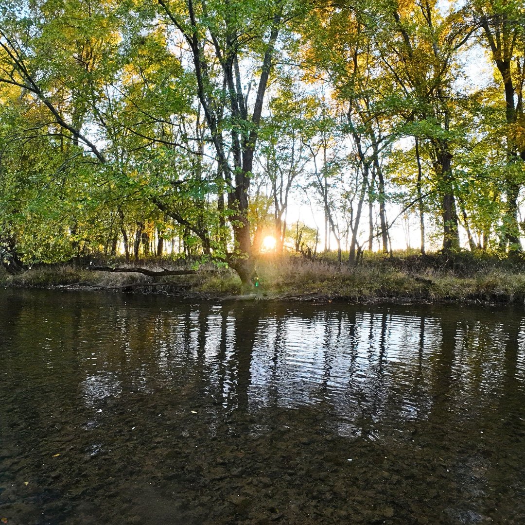 Sunset over a Northeast Ohio creek in early fall with warm seasonal colors.