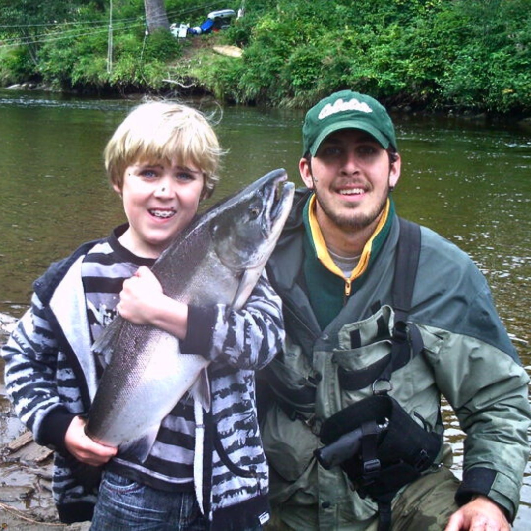 Guide Matt Campbell and client with a fresh Coho Salmon caught while fly fishing a coastal creek in Southeast Alaska.