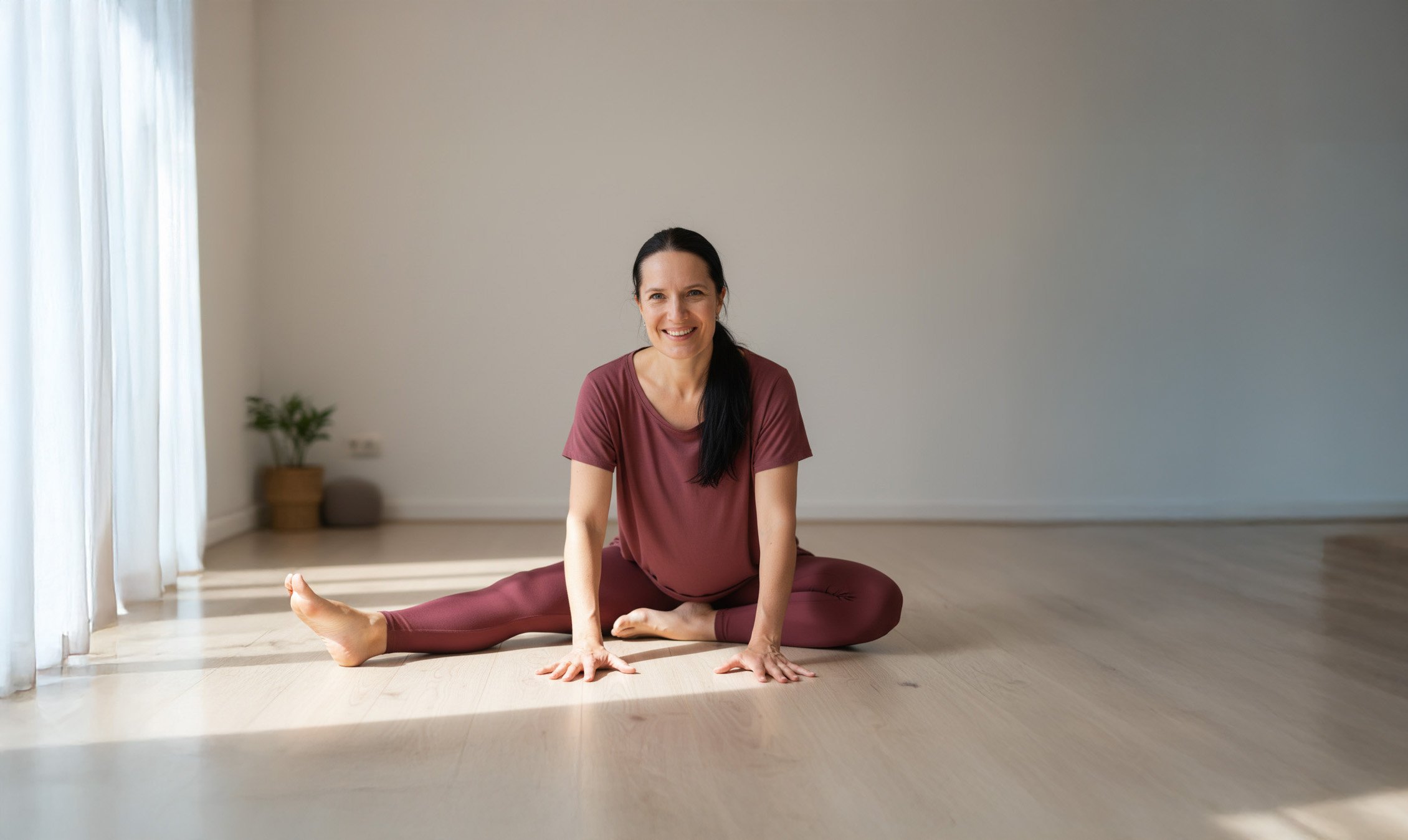 Mette sittign on the floor teaching yoga in a studio