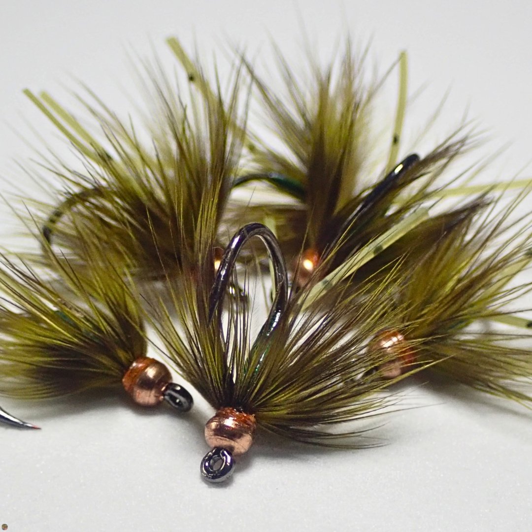 Small pile of Olive Lil Dynamite wet flies, designed by Matt Campbell for trout, panfish, and carp.