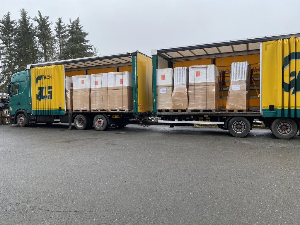 Win-Win mit Restposten Großhandel: Ein zufriedener Wiederverkäufer präsentiert seine neu eingetroffene Mischpalette von Salzmann Restwaren. So steigern Sie Ihren Umsatz mit günstiger Ware und niedrigen Großhandelspreisen