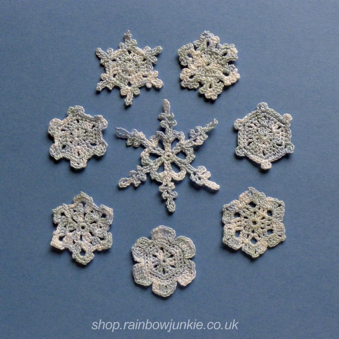 All eight snowflakes made in mixed blue and white #10 thread on a mid blue background.