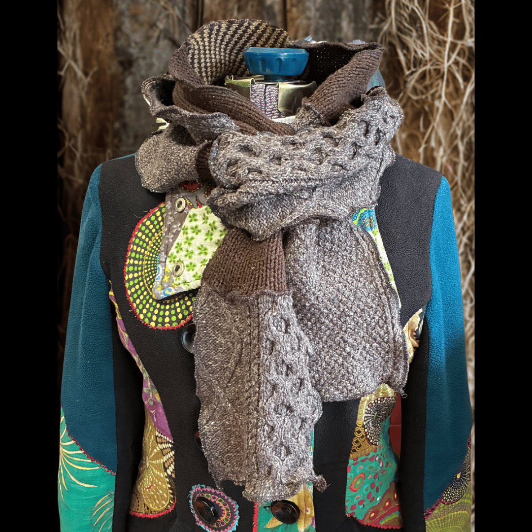 Upcycled scrappy scarf made from rescued cable-knit sweaters in soft browns and neutral tones, handcrafted for cozy, earthy vibes by What in Narnation.