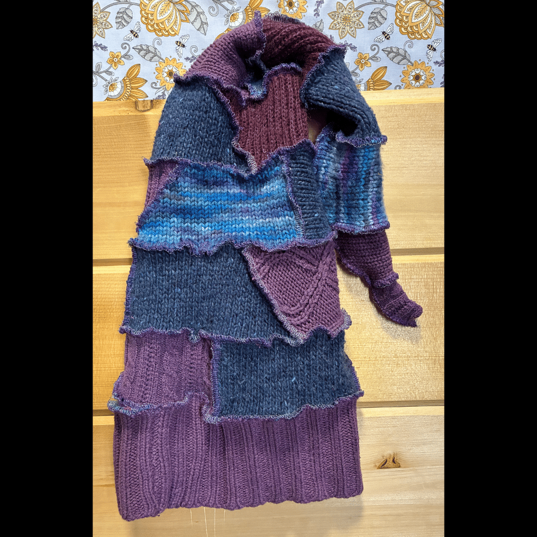 Handmade upcycled scrappy pixie hat in deep plum and midnight blue tones, crafted from rescued sweaters with whimsical wavy edges by What in Narnation.
