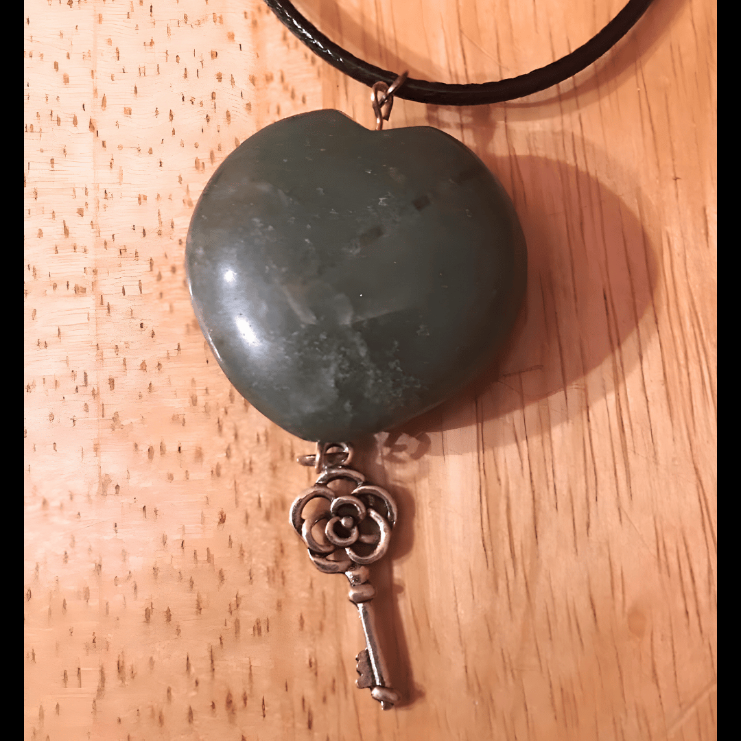 Handmade pendant featuring a dark green heart-shaped stone with a wire-wrapped vintage key charm, crafted by What in Narnation.