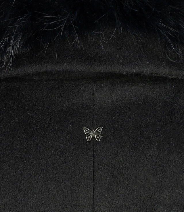 Naheansicht des modischen schwarzen Mantels mit dekorativem Schmetterlings-Emblem auf dem Rücken.