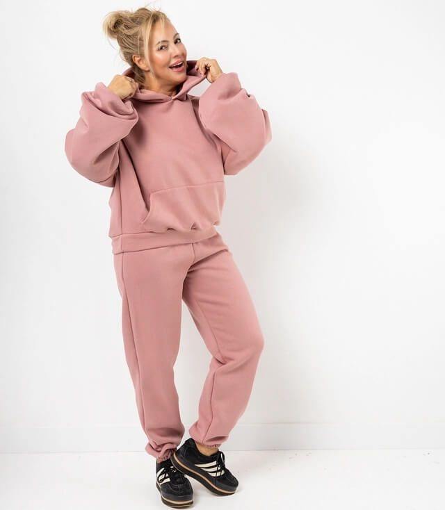 Frauen-Pullover und Jogginghose in Rosa mit Kapuze und großen Ärmeln für einen lässigen Look.