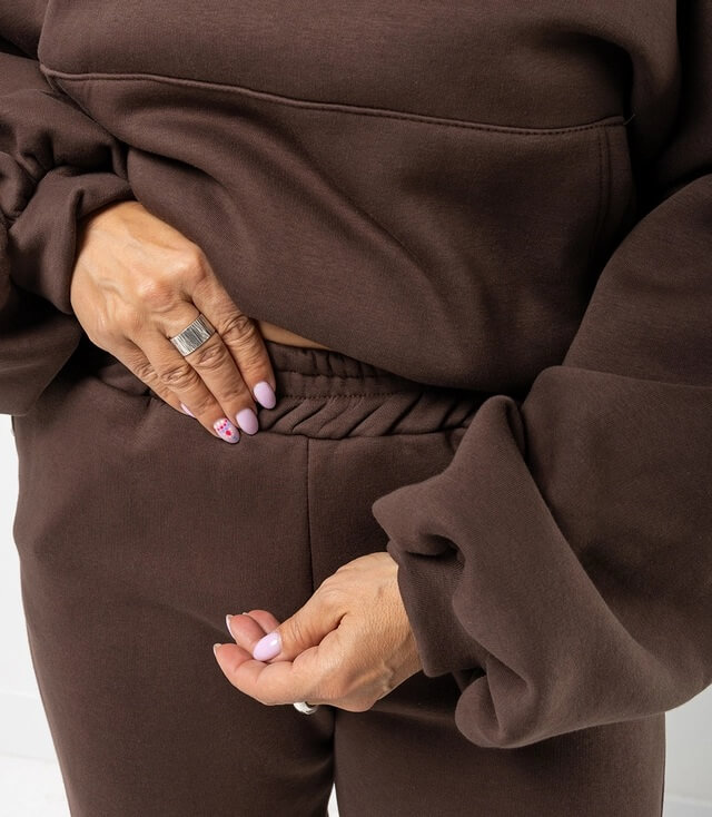 Braune Lounge-Wear mit lässigem Sweatshirt und bequemer Hose, ideal für entspannte Tage.