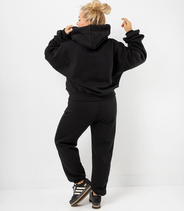 Schwarzer  Hoodie und Jogginghose aus Baumwolle, mit Kapuze und lässigem Schnitt von hinten gesehen.