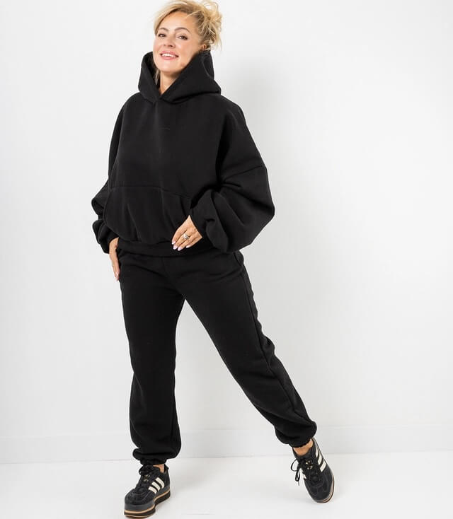 Schwarzer Sweatanzug: weite Kapuzenoberteil und passende Jogginghose für lässigen Look