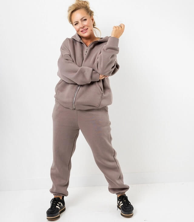 Bequeme Damen-Sweatjacke mit Reißverschluss in Braun, lässig kombiniert mit Sweatpants und Sneakers.