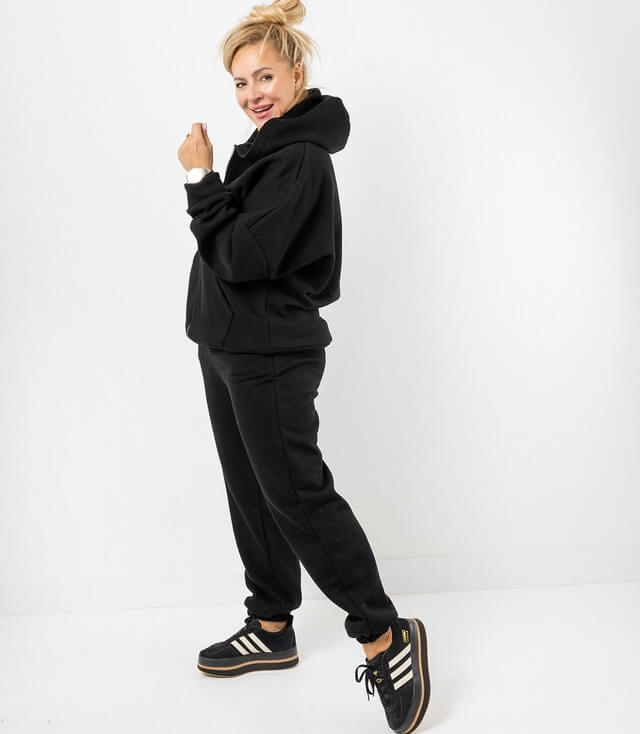 Modischer schwarzer Sweatshirt mit Kapuze und passende Jogginghose für lässigen Look.