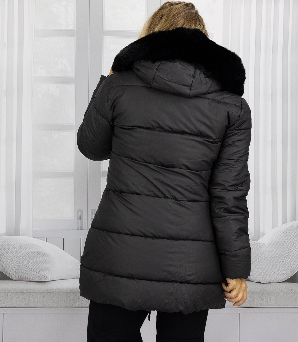 Schwarze Winterjacke mit Kapuze und Faux-Fur-Kragen, von hinten fotografiert