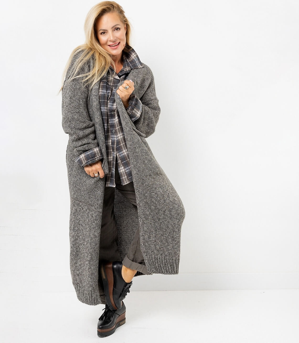 Modischer grauer Longcardigan mit lässigem Schnitt, kombiniert mit kariertem Hemd und bequemer Hose.