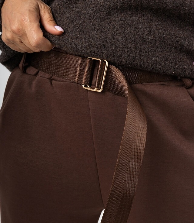 Brauner Bund mit goldener Schnalle an einer Hose, die stilvoll und modern aussieht.