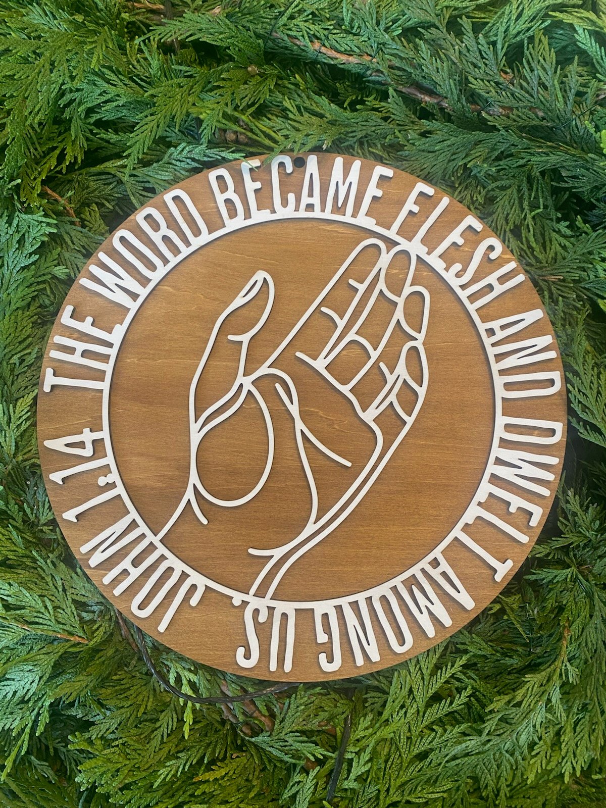 Laser cut wooden sign with Bible verse The Word Became Flesh and Dwelt Among Us.