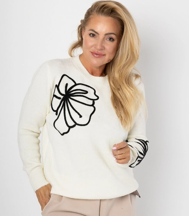Weißer Pullover mit großen schwarzen Blumenstickereien an den Ärmeln, eleganter Look für den Alltag.