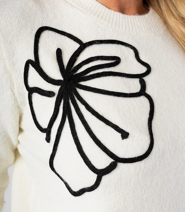 Weißer Pullover mit schwarzem Blumenmuster auf der Vorderseite für einen lässigen Look.