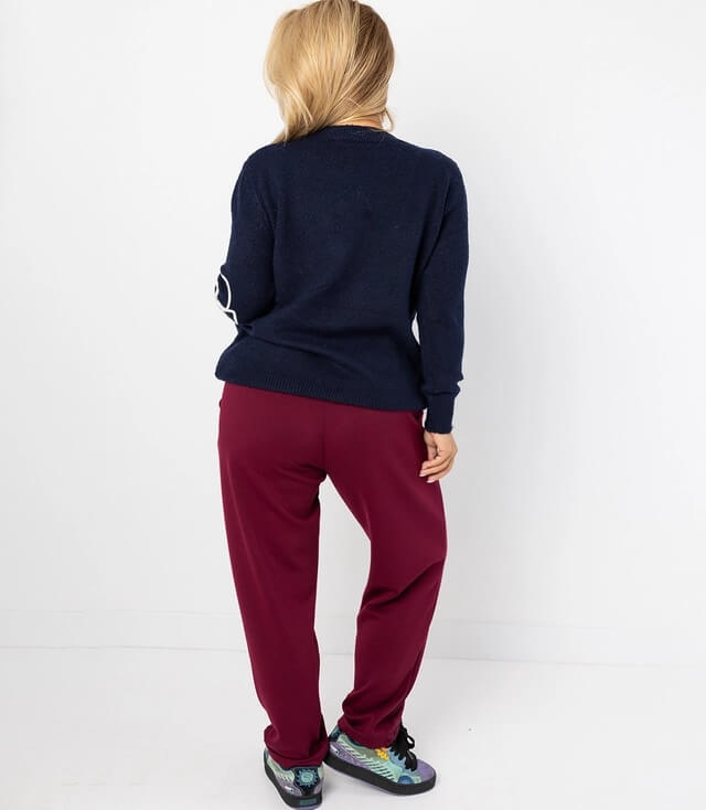 Damen-Outfit mit dunkelblauem Pullover und bordeauxfarbenen Jogginghosen von hinten gesehen, sportlich und bequem.