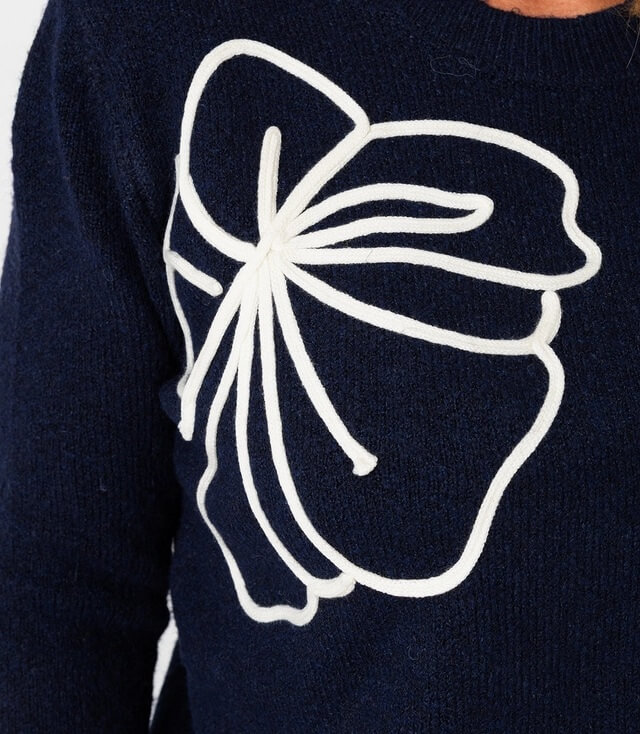 Dunkelblauer Pullover mit weißem Blumenmuster auf der Vorderseite, elegant und lässig.