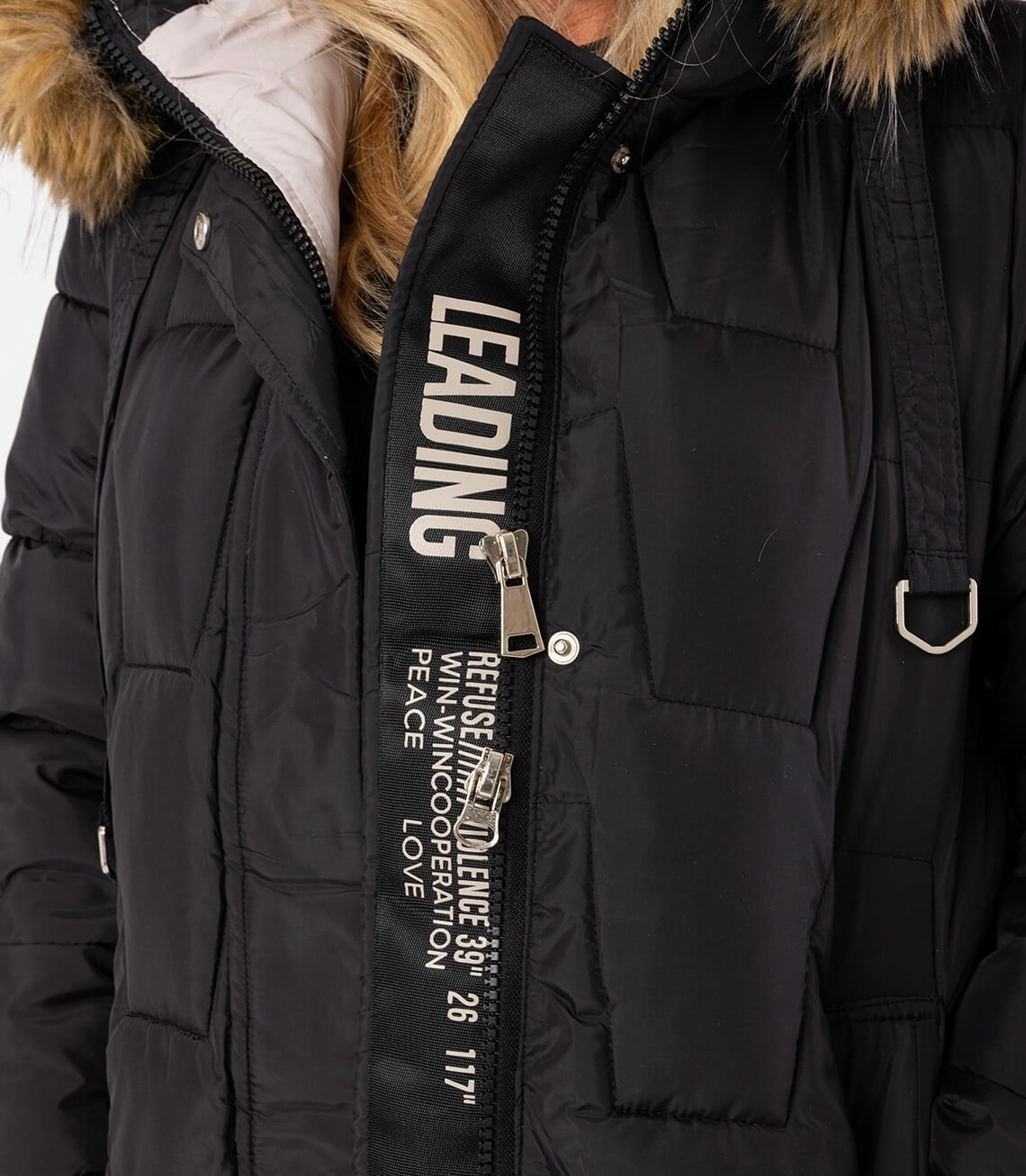 Detailansicht der geschlossenen Jacke mit Reißverschluss und auffälliger Schrift auf dem Zipper.