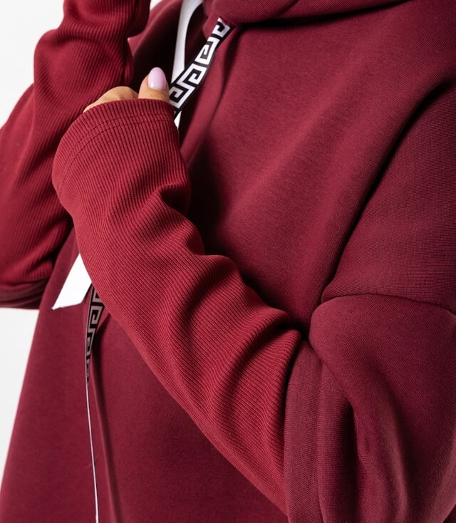 Detailansicht des bordeauxroten Hoodies mit Kapuze und stylischem Zipper, der farblich abgesetzt ist.