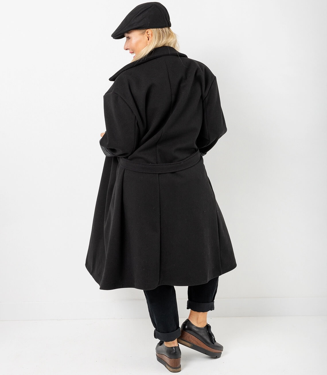 Langer Damen Mantel in Schwarz: Rückansicht mit Gürtel und weitem Schnitt.