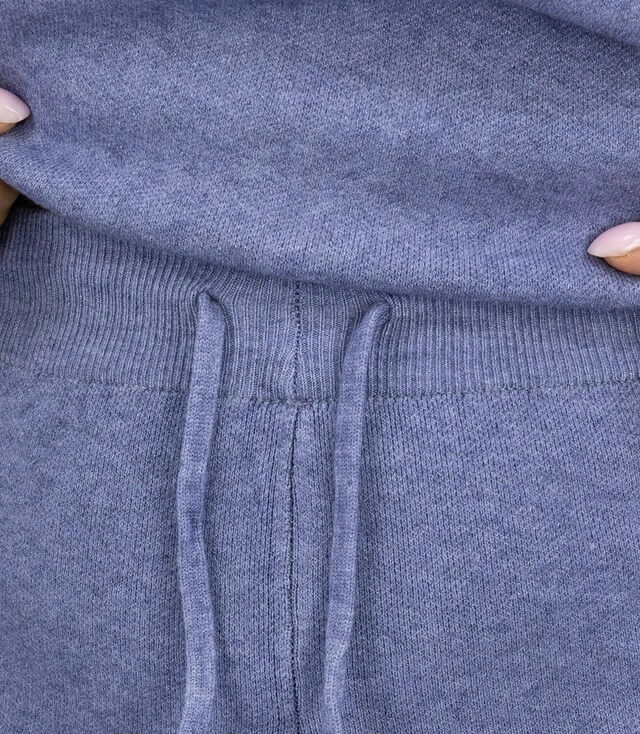 Detailaufnahme des Bunds einer blauen Jogginghose mit Kordelzug und elastischem Material.