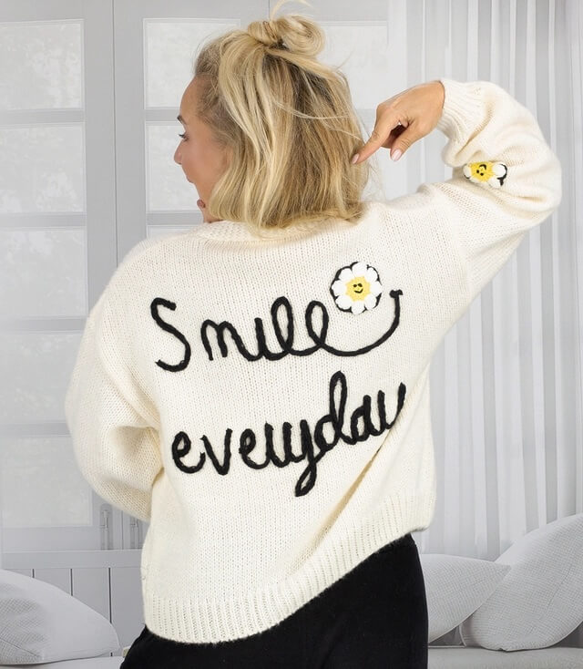 Weiche Damen Strickjacke  mit aufgesticktem Spruch "Smile every day" und Blumendetails auf der Rückseite.