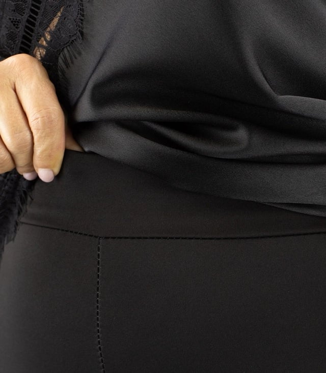 Fokus auf die Taille einer schwarzen Leggings mit elastischem Bund und hochwertigem Material.