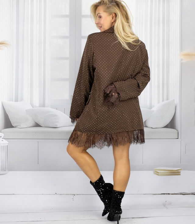 Brauner lange Blazer mit Pailletten und Spitzenabschluss, von hinten fotografiert, mit schmalen Stiefeln.