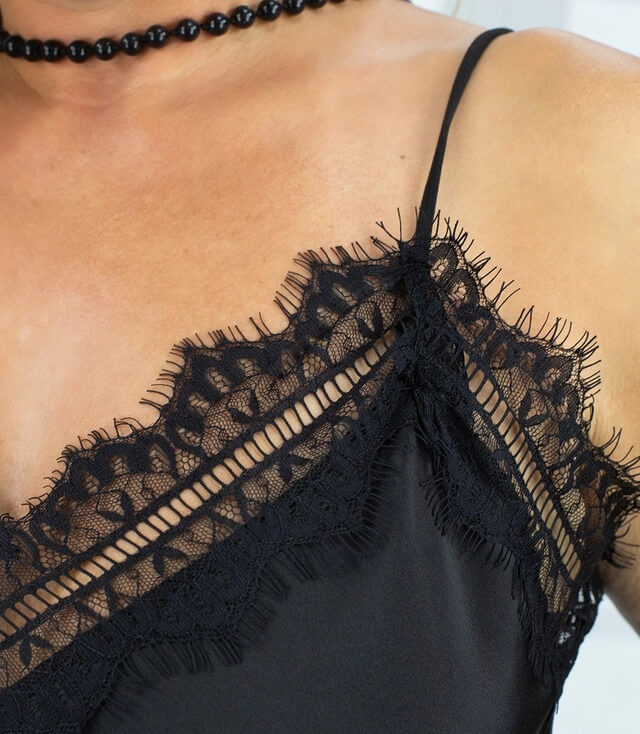 Detailansicht des schwarzen Spitzentops mit feinen Spitzen und Spagettiträgern.