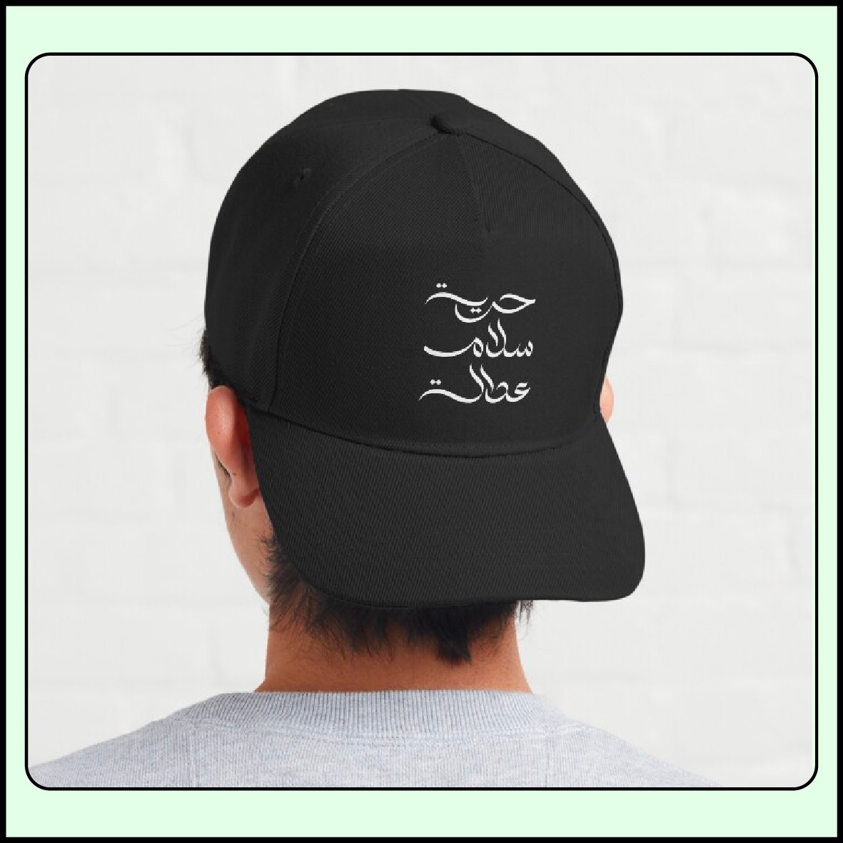 Arabic calligraphy design, expressing freedom, peace, and justice, is displayed on a baseball cap mockup by ArabicVectors