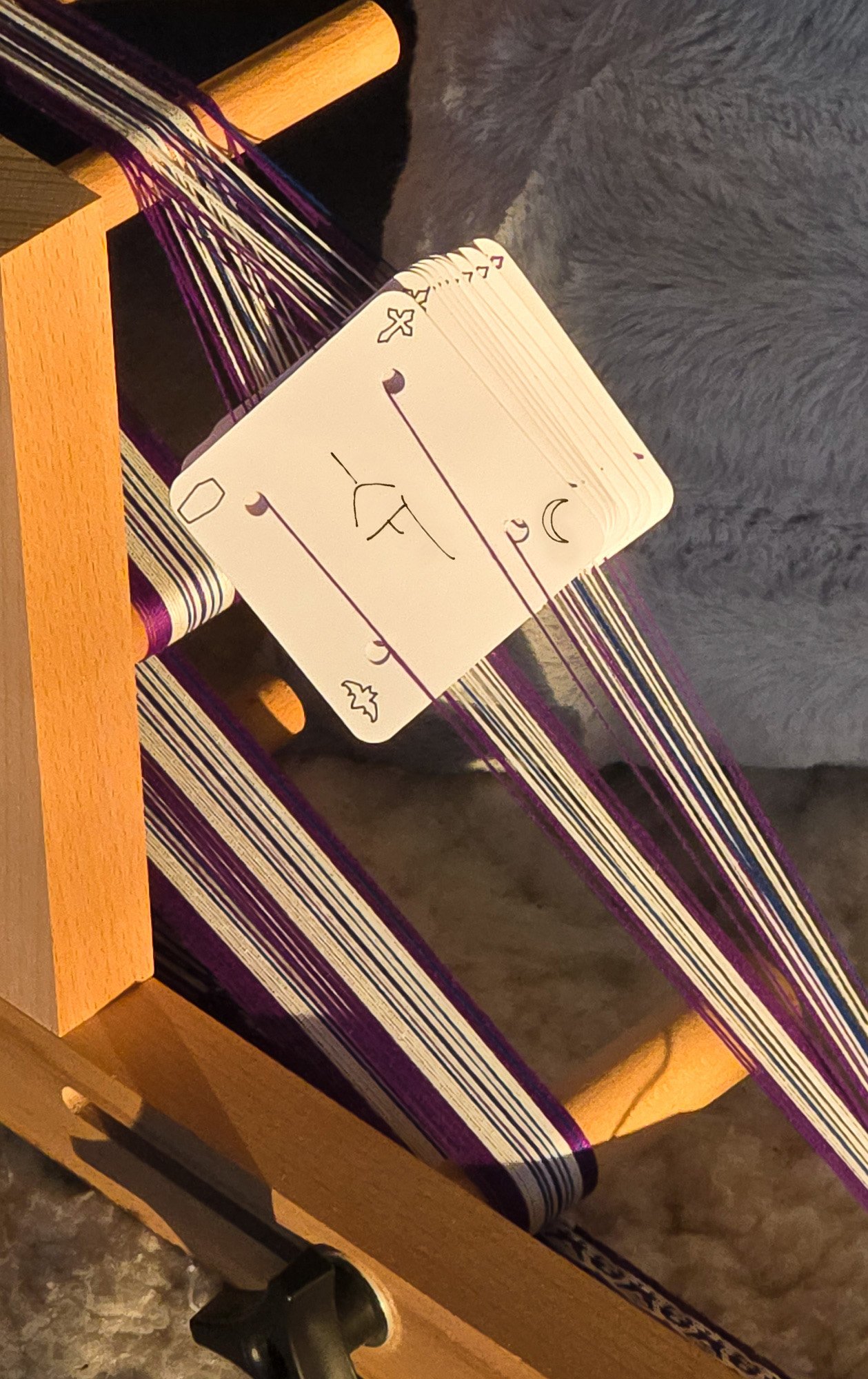 close up of tablet weaving cards threaded onto an inkle loom